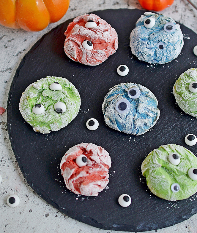 Fun and delicious Monster Cookies for Halloween in fun colors with silly candy eyeballs. Soft and Chew cookie recipe made with a cake mix.